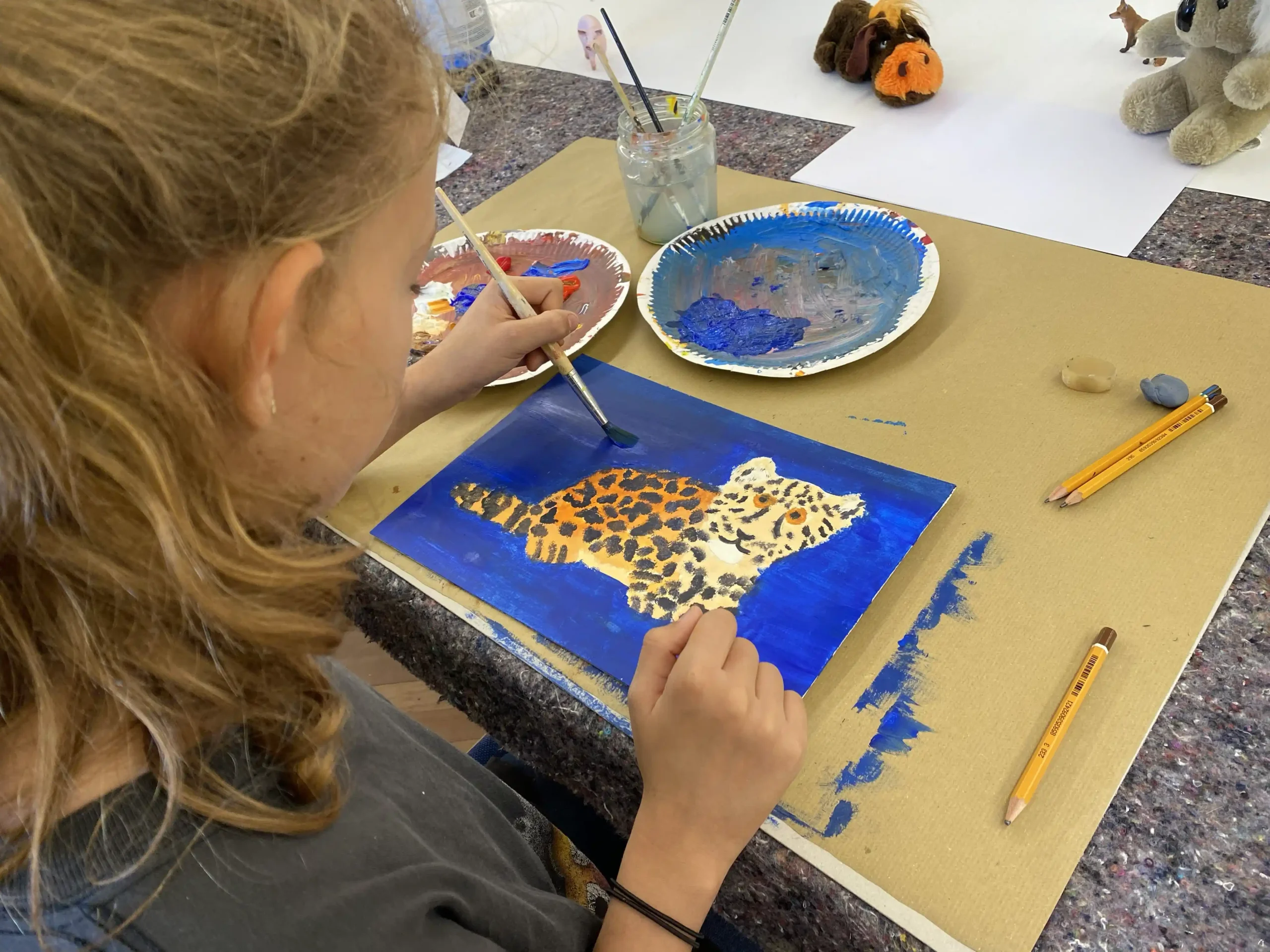 Kind malt einen Tiger mit Acrylfarbe